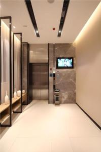 武汉City Comfort Inn Wuhan Xudong Street Wangjiadun Metro Station的电梯大厅,墙上有电视