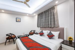 新德里Hotel The Gold Inn Karol Bagh Delhi的一间卧室配有一张床、一张书桌和一个窗户。