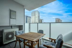 悉尼201B City View 2Bedroom Apt nr Plaza and Train Central with Free Parking的带阳台的带桌椅的房间