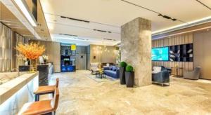 贵阳Echarm Hotel Guiyang Qianling Mountain的一个带沙发和椅子的酒店大堂