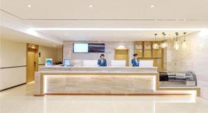 贵阳City Comfort Inn Guiyang Wanda Plaza Jiufu City的两名妇女站在厨房的柜台上