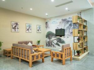 苏州GreenTree Inn Express Suzhou Luzhi Ancient Town Scenic Area Xiaoshi Road的带沙发的客厅和墙上的电视