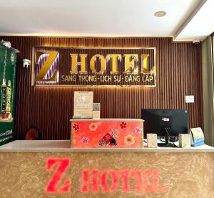 胡志明市Z Hotel Sài Gòn的墙上挂有酒店标志的酒店接待处