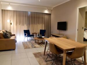 比勒陀利亚Menlyn Maine Luxury Rentals的客厅配有桌子和沙发