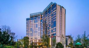 贵阳New World Guiyang Hotel的一座高大的建筑,有很多窗户