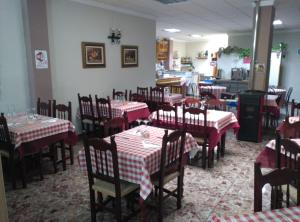 隆达圣女罗西奥旅馆的餐厅设有红色和白色的桌椅