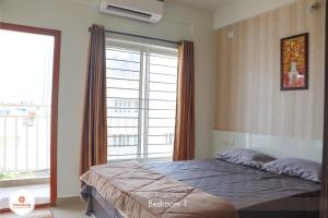 班加罗尔Staymazing Ferndale-1,2&3 BHK Boutique Serviced Apartment- Hebbal的一间卧室设有一张床和一个大窗户