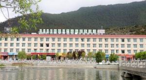 林芝GreenTree Inn Tibet Nyingchi City Biji Shenshan的水体旁的白色大建筑