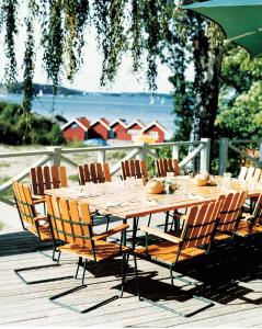 格林达Grinda Wärdshus的一张木桌和椅子,坐在甲板上