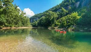 PoncaBuffalo River Glamping的一条河里,有一群红色的皮艇在水里