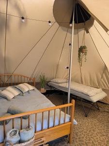 罗斯诺夫·波德·拉德霍斯滕Glamping Rožnov的一间卧室,配有带一张床和长凳的帐篷