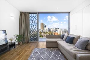 悉尼2BR Luxury Stay in Ultimo的带沙发和大窗户的客厅