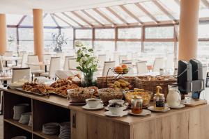 高塔特拉山Rodinný Hotel Hubert High Tatras的自助餐,包括面包和其他食物在餐桌上