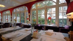 阿姆斯特丹阿波罗第一精品酒店的用餐室设有桌椅和窗户。