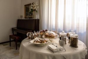 塔兰托罗莎德翁蒂住宿加早餐酒店的一张桌子,上面有白色的桌布,上面有食物