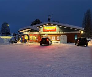 LillhärdalHärjulfs hus的两辆汽车停在商店前面的雪地里