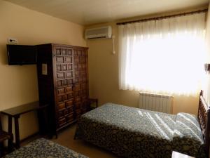 奥卡尼亚朋友旅馆的一间卧室配有一张床、一个梳妆台和一扇窗户。