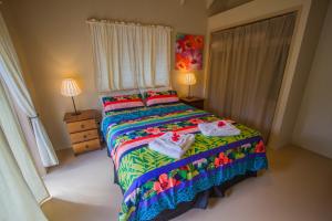 拉罗汤加Cook Islands Holiday Villas - Muri Lagoon Beachfront的一间卧室配有带毛巾的床