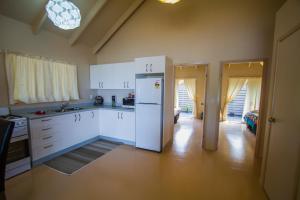 拉罗汤加Cook Islands Holiday Villas - Muri Lagoon Beachfront的厨房配有白色橱柜和冰箱。