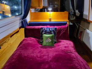 伦敦Cosy Canal Boat in Little Venice by Paddington for Family & Friends的一张紫色的床,上面有枕头