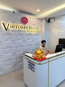 胡志明市Motel Victoria的坐在前台手提电脑的人