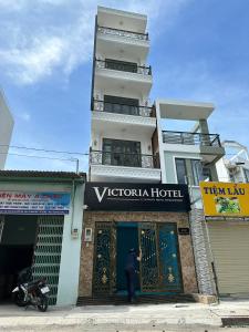 胡志明市Motel Victoria的站在建筑物前的人