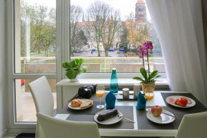 格但斯克斯维托扬斯卡公寓的一张桌子,上面有食物和饮料,还有一个窗口