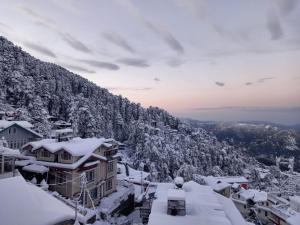 西姆拉Valleyview Open Balcony Near Ridge Mall Shimla的被雪覆盖的山地小镇