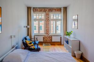 莱比锡Hostel Multitude的卧室配有床、椅子和窗户。