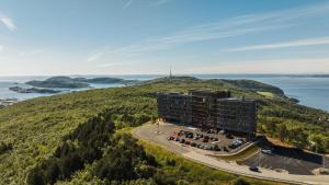 波多Wood Hotel Bodø的水边山丘上建筑物的空中景观