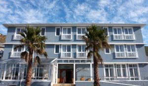 钓鱼镇卡尔德斯会议中心酒店的一座蓝色的建筑,前面有棕榈树