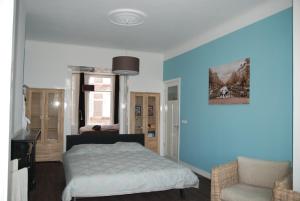 海牙欧泊里齐特斯特拉特住宿加早餐旅馆的卧室拥有蓝色的墙壁,配有一张床和椅子