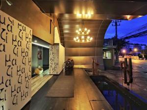芭东海滩Mazi Design Hotel by Kalima - SHA Plus的一座带游泳池和吊灯的建筑