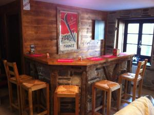 圣拉里苏朗Au Chant Des Marmites的一间酒吧,房间设有木墙和椅子