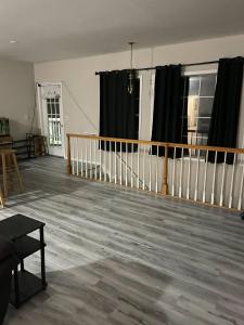 绍斯伯里Private Apt In Southfordsouthbury的空客厅配有黑色窗帘和木地板