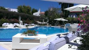 罗萨玛里纳Villa Rosamarina的一个带白色椅子和桌子的游泳池