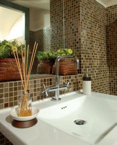 罗马特米诺酒店的浴室水槽和柜台上的花瓶