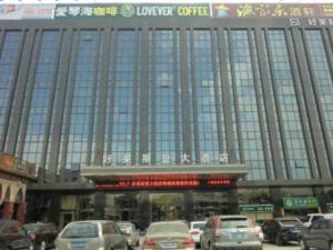 泉州Quanzhou Jinjiang Hollyston Hotel的一座大型建筑,前面有汽车停放