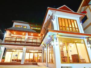 帕府The Indigo House Phrae的夜间在建筑物前的商店