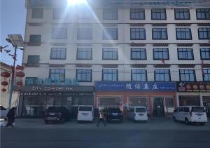 堆龙德庆City Comfort Inn Lhasa Gongga County Gongga Airport的前面有汽车停放的建筑