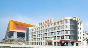 花都Vienna Hotel Guangzhou Huadu Financial Center Sunac Amusement Park的一座大建筑,上面有标志