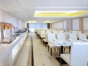 NaguiVienna Hotel Guangxi Fusui的用餐室配有白色的桌子和白色的椅子