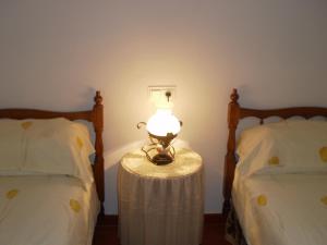 比纽埃拉La Atalaya de Los Romanes的一张桌子上的灯,旁边是两张床