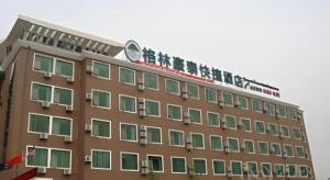 北京GreenTree Inn Beijing Capital Airport New International Exhibition Center Express Hotel的顶部有钟的建筑