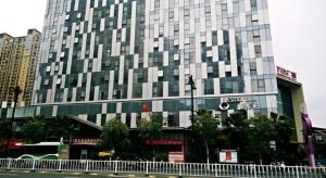 泉州Metropolo Hotel Jinjiang Wudian Wanda Plaza的城市街道上一座带窗户的大型建筑