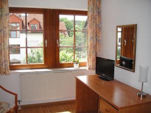 艾森纳赫An der Linde的客房设有书桌、电视和窗户。