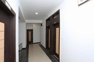 博帕尔Super Hotel O Danish Nagar Hosangabad Rd的走廊设有黑色门和白色墙壁