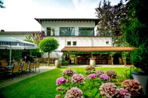 奥斯纳布吕克唯宝科尔布勒奇尔酒店餐厅及SPA的花园设有桌椅和鲜花