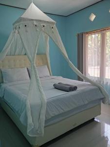 RiungRIUNG LALONG TERONG Guest House的卧室内的一张带白色天蓬的床