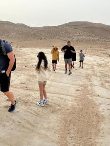 米德希特本-古里安אוהל בוסתן הזיתים的一群人走在沙漠中